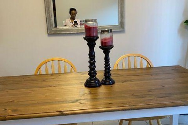 Wooden dining table with chairs, black candle holders, and a reflection in the mirror. - 1704 - 530 Lolita Gardens, Mississauga