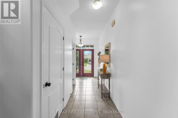 Spacious foyer with tiled floor, white walls, and a glass-paneled front door. - 1704 Reginald Bart Drive, Kingston)