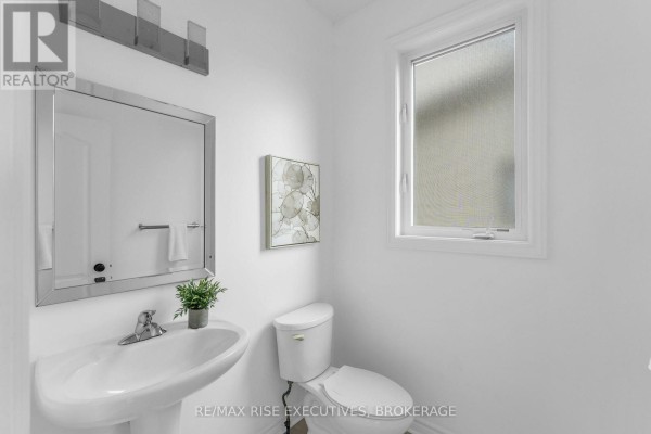 Powder room with white pedestal sink, toilet, and a frosted window. - 1704 Reginald Bart Drive, Kingston)
