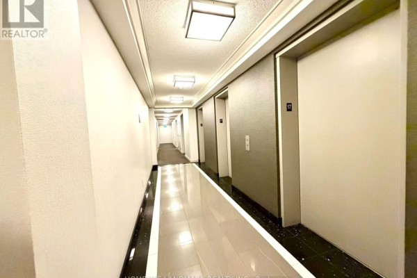 Long, brightly lit hotel-style hallway with elevators and carpeted floor. - 1706 - 18 Parkview Avenue, Toronto