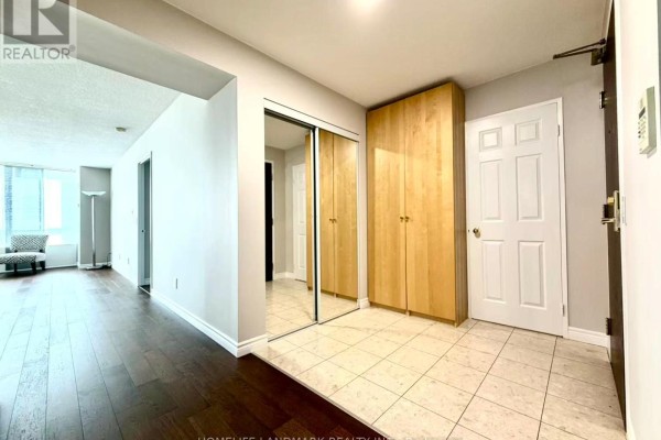 Apartment entryway with dark wood floors, tiled area, and mirrored closet doors. - 1706 - 18 Parkview Avenue, Toronto