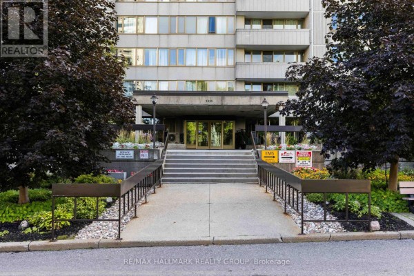 Wide angle view of the exterior of a tall concrete apartment building. - 1706 - 2625 Regina Street, Ottawa
