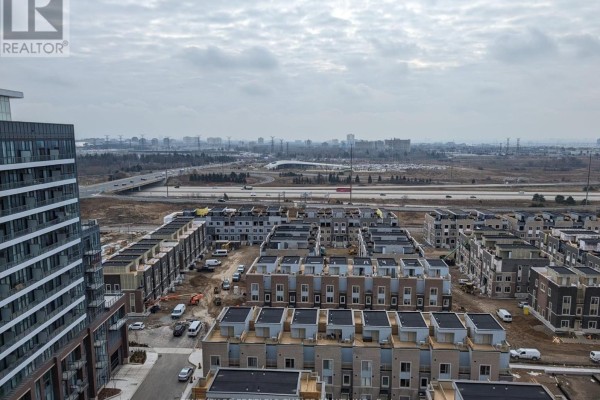 Overhead view of a suburban development with townhouses and a highway in the distance. - 1706 - 38 Honeycrisp Crescent, Vaughan