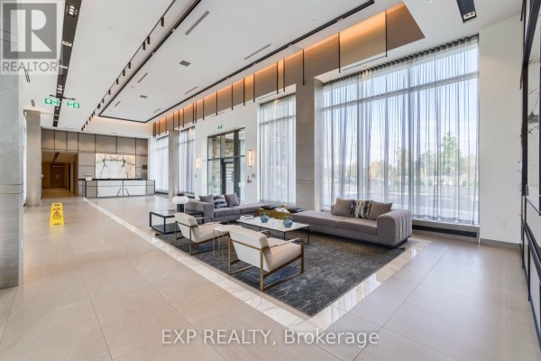 Spacious lobby of an apartment building with contemporary furniture, decorative lighting, and marble floors. - 1707 - 4675 Metcalfe Avenue, Mississauga