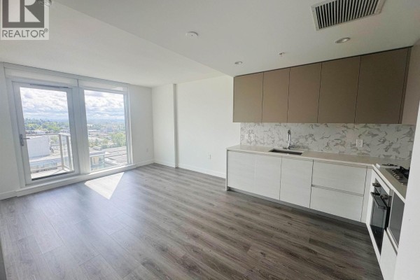 Open concept living area with a kitchen, large windows, and a sliding glass door to a balcony. - 1708 8188 Fraser St, Vancouver