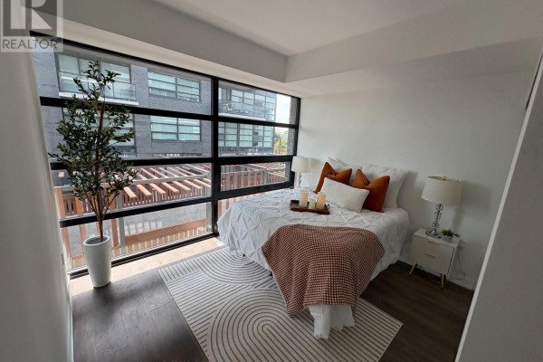 Bedroom with a queen-size bed, white bedding, and large windows with city views. - 171 - 1610 Charles Street, Whitby