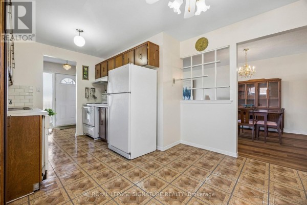 Renovated kitchen with stainless steel appliances, grey cabinetry, and tiled flooring, open to dining area. - 171 Petworth Crescent, Toronto
