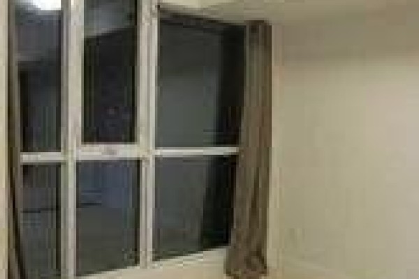 A corner window with silver frames and brown curtains in an empty room. - 1710 - 295 Adelaide Street W, Toronto