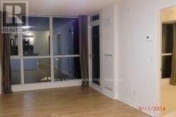 A living area with large floor-to-ceiling windows and light hardwood floors. - 1710 - 295 Adelaide Street W, Toronto