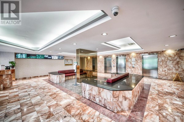 The building lobby features marble floors, stone accent walls, seating areas, and elevator access. - 1710 - 5 Rowntree Road, Toronto