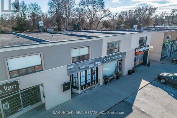 Overhead view of a commercial building's roof and surrounding storefronts including Hee Sushi and MelaKitchen. - 1710 Lakeshore Road W, Mississauga