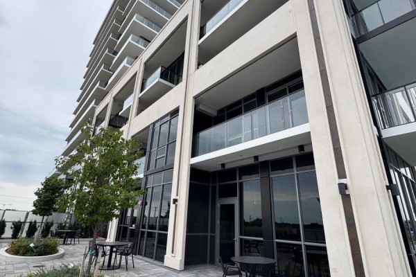 Outdoor seating area with tables and chairs next to a modern building. - 1711a - 115 Nipissing Road N, Milton