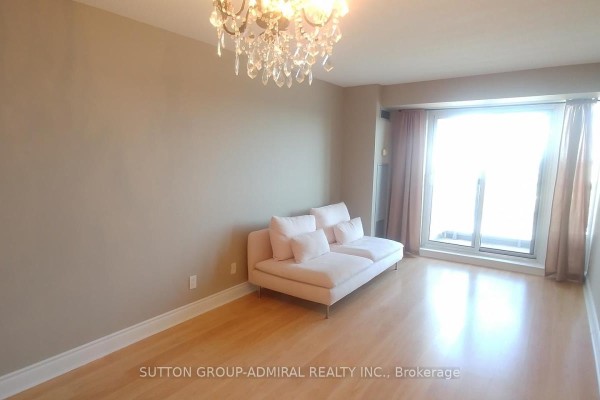 Living room with light wood floors, beige walls, a pink sofa, and a large window. - #1712 - 7 North Park Road, Vaughan