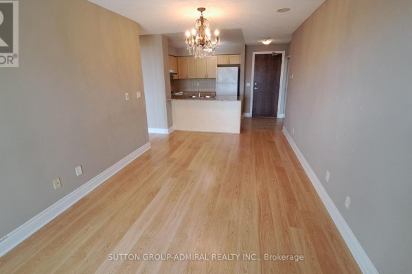 Living room with light wood floors, beige walls, a pink sofa, and a large window. - #1712 - 7 North Park Road, Vaughan