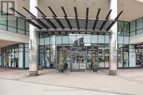 Entrance to the Pinnacle Centre with large glass doors, metal canopy, and planters. - 1713 - 16 Yonge Street, Toronto