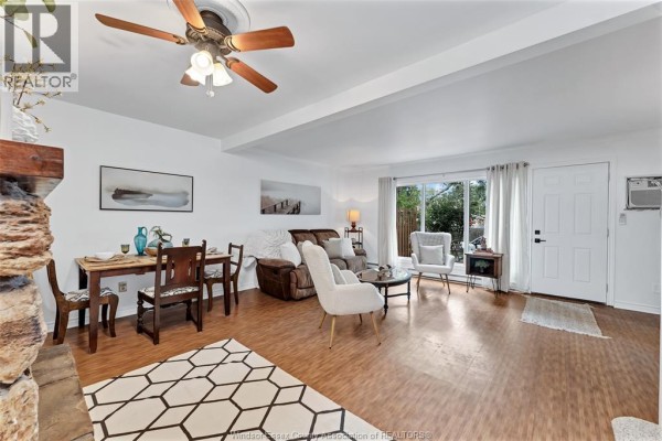 Living and dining area with wood floors, white walls, and patio doors. - 1716 Eastgate Estates, Windsor