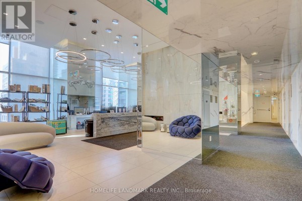 Building lobby with seating, modern art, mirrored walls, and fireplace. - 1718 - 251 Jarvis Street, Toronto