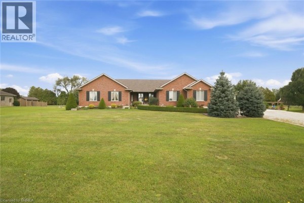 Brick bungalow with black shutters and manicured lawn under a blue sky. - 172 Highway 53, Cathcart