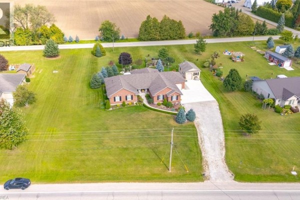 Aerial view of brick bungalow with large lawn, detached garage and surrounding fields. - 172 Highway 53, Cathcart