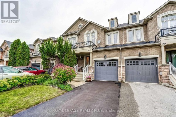 Street view of a brick townhouse with garages and balconies. - 172 Lauderdale Drive, Vaughan