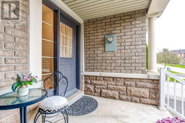 Close-up of the townhouse entrance porch with a small table and chairs. - 172 Lauderdale Drive, Vaughan