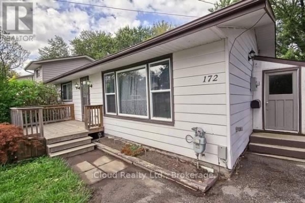 Close-up exterior view of the white bungalow, showing the address number, a small door, and a gas meter. - 172 Silas Boulevard, Georgina