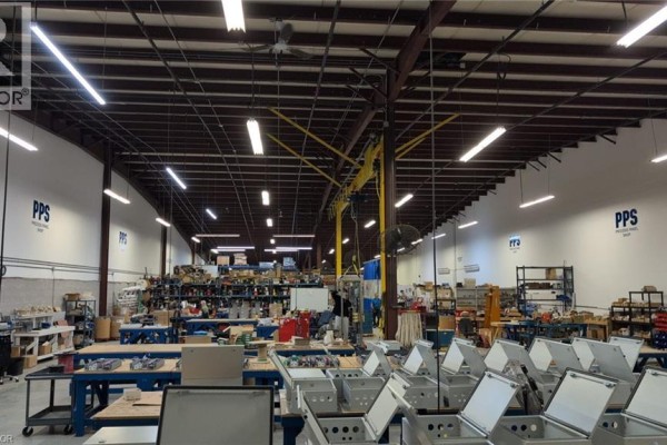 Interior view of a large warehouse space with shelving, equipment, and metal enclosures. - 1720 Bishop Street N Unit# 3, Cambridge
