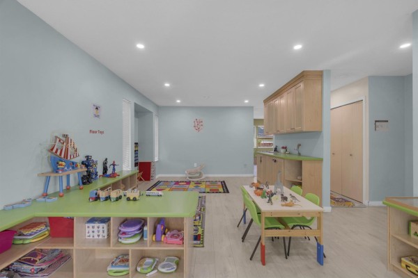 Interior of a brightly lit room with light blue walls, tables, chairs, and shelving. - 17209 62a Avenue, Surrey