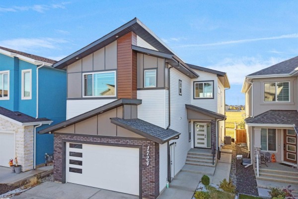 Front exterior of a contemporary house with a mix of white siding and dark accents. - 1724 19 St Nw, Edmonton