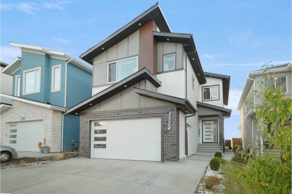 Daytime exterior view of a modern house with a large garage and contrasting siding. - 1724 19 St Nw, Edmonton
