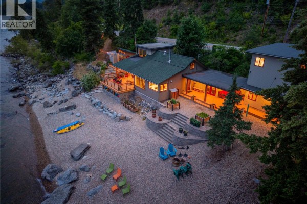 Evening aerial view of the home and its rocky beach yard with outdoor seating and fire pit. - 1726 31 Highway, Queens Bay
