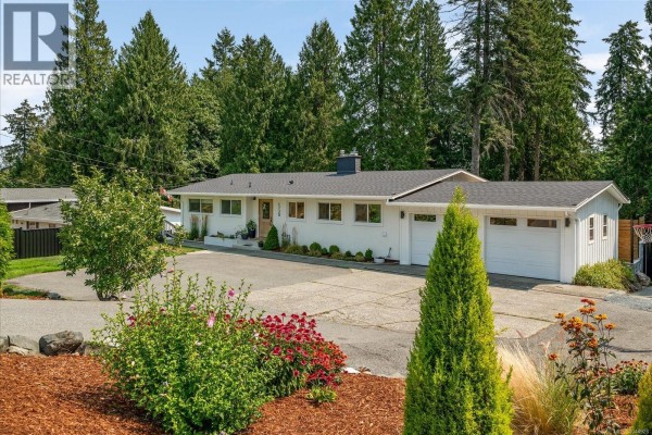 White ranch-style house with attached double garage and large driveway. - 1728 Extension Rd, Nanaimo
