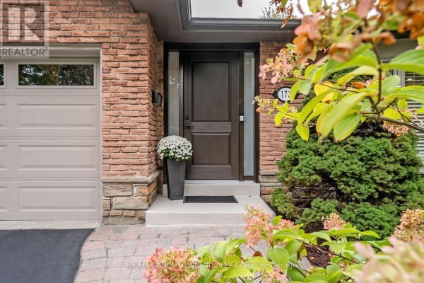 Close-up of dark brown front door with stone and brick exterior. - 173 Arichat Road, Oakville