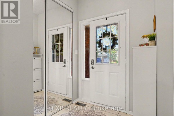 Entrance foyer with a white door, side window, and a large mirrored closet door on the left. - 173 Beatrice Drive, Ottawa