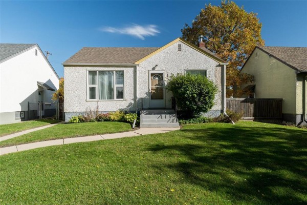 Front exterior of a white stucco house with a manicured lawn and a curving sidewalk. - 173 Belmont Avenue, Winnipeg