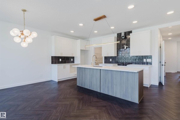 Spacious kitchen and dining area with white cabinets, island, and large windows. - 1731 Crossbill Lo Nw, Edmonton