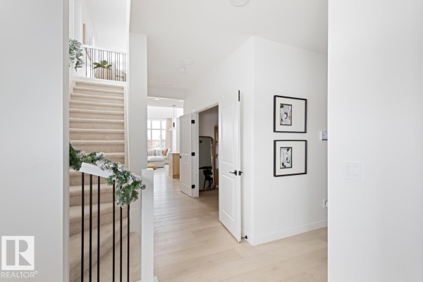 Interior entryway with staircase, hallway, and two framed pictures on the wall. - 1731 Crossbill Lo Nw, Edmonton