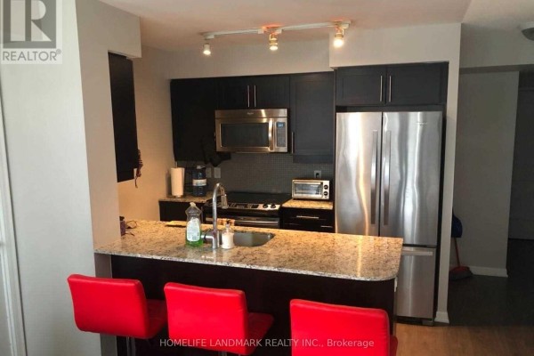 Compact kitchen with dark cabinets, granite counters, stainless steel appliances, and red bar stools. - 1732 - 38 Grand Magazine Street, Toronto