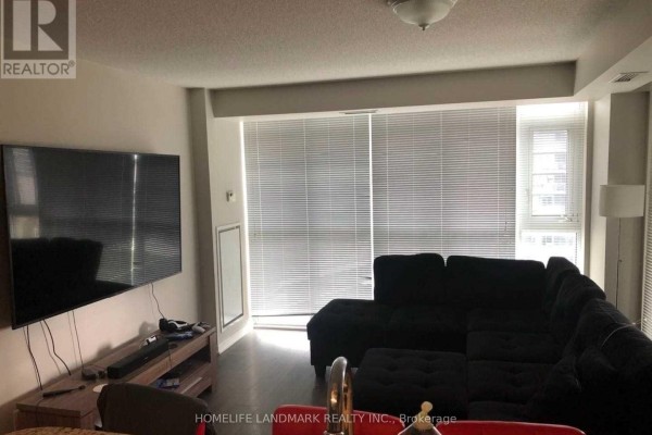 Living room with a large sectional sofa, entertainment unit, and wide blinds covering windows. - 1732 - 38 Grand Magazine Street, Toronto
