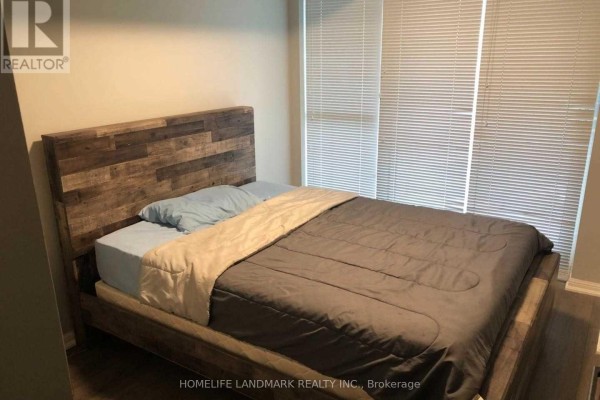 Bedroom with a queen-size bed, rustic wooden headboard, and windows with horizontal blinds. - 1732 - 38 Grand Magazine Street, Toronto