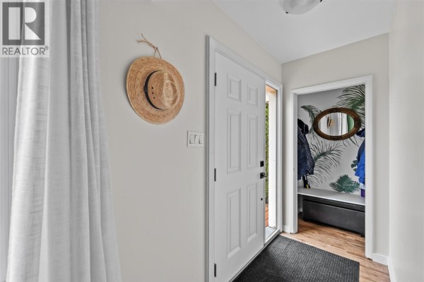 Kitchenette with white uppers, blue lowers, stainless steel shelving, and a white door. - 1735 Quilchena Avenue, Merritt