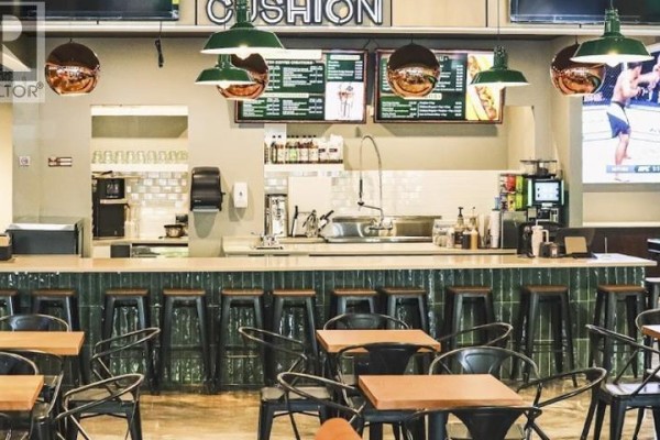 Bar area with green tiled backsplash, metal stools, wooden tables, and menu boards overhead. - 1736 Confidential Street, Delta