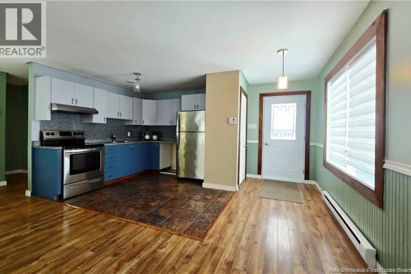 Open kitchen with stainless steel appliances and blue cabinetry - 1737 Route 355, Sainte Rose
