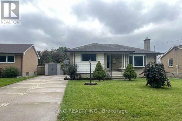 Front exterior of a house with a stone and white siding, under a cloudy sky. - 1737 Wavell Street, London East