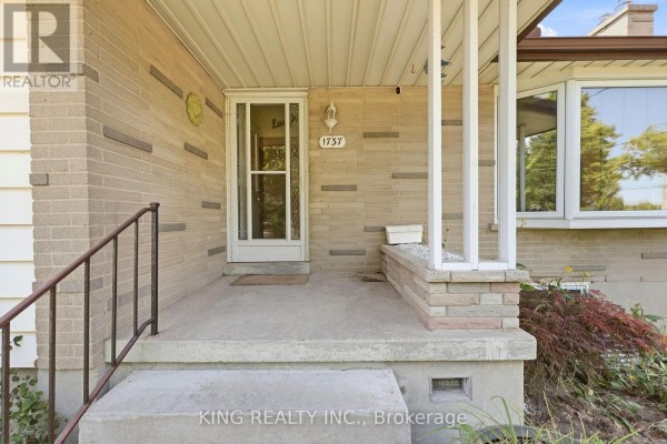 Close-up of the front porch entrance with a glass door, brick pillars, and steps. - 1737 Wavell Street, London East