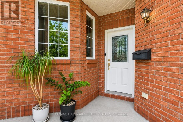 Covered front porch with white door, ornate glass, and mail slot. - 174 Carwood Circle W, Ottawa