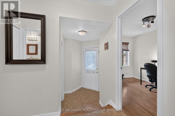 Dining area with dark wood table, chairs, and hardwood floors. - 174 Carwood Circle W, Ottawa