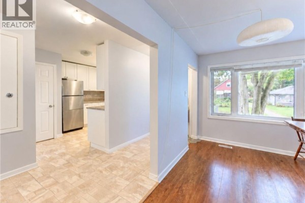 View from dining area into kitchen. Dining area has wood floors and large window with exterior view. - 174 Glen Road, Kitchener