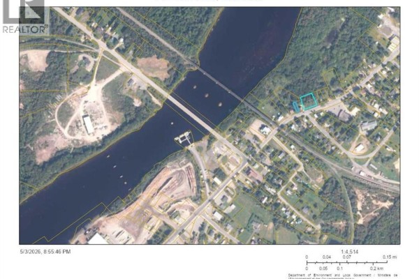 Aerial view of the Chipman area showing the property lot near the river, a bridge, and surrounding buildings. - 174 Main Street, Chipman