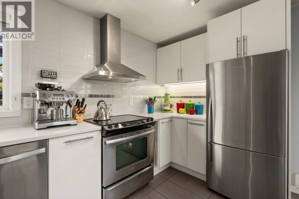Close-up of a kitchen with stainless steel appliances, stove, and coffee machine. - 1741 Chesterfield Avenue, North Vancouver